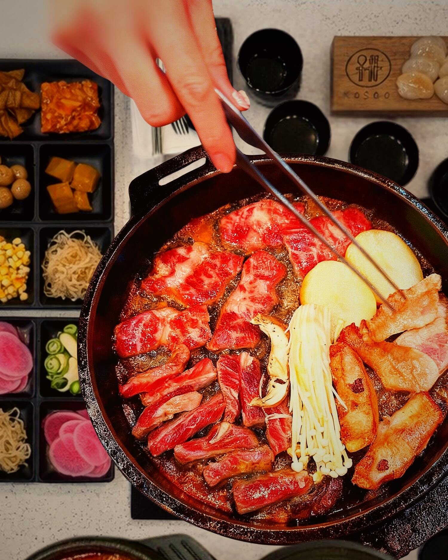 Bubbling Korean BBQ hot pot with premium meats at KOSOO Coquitlam, banchan side dishes around the table