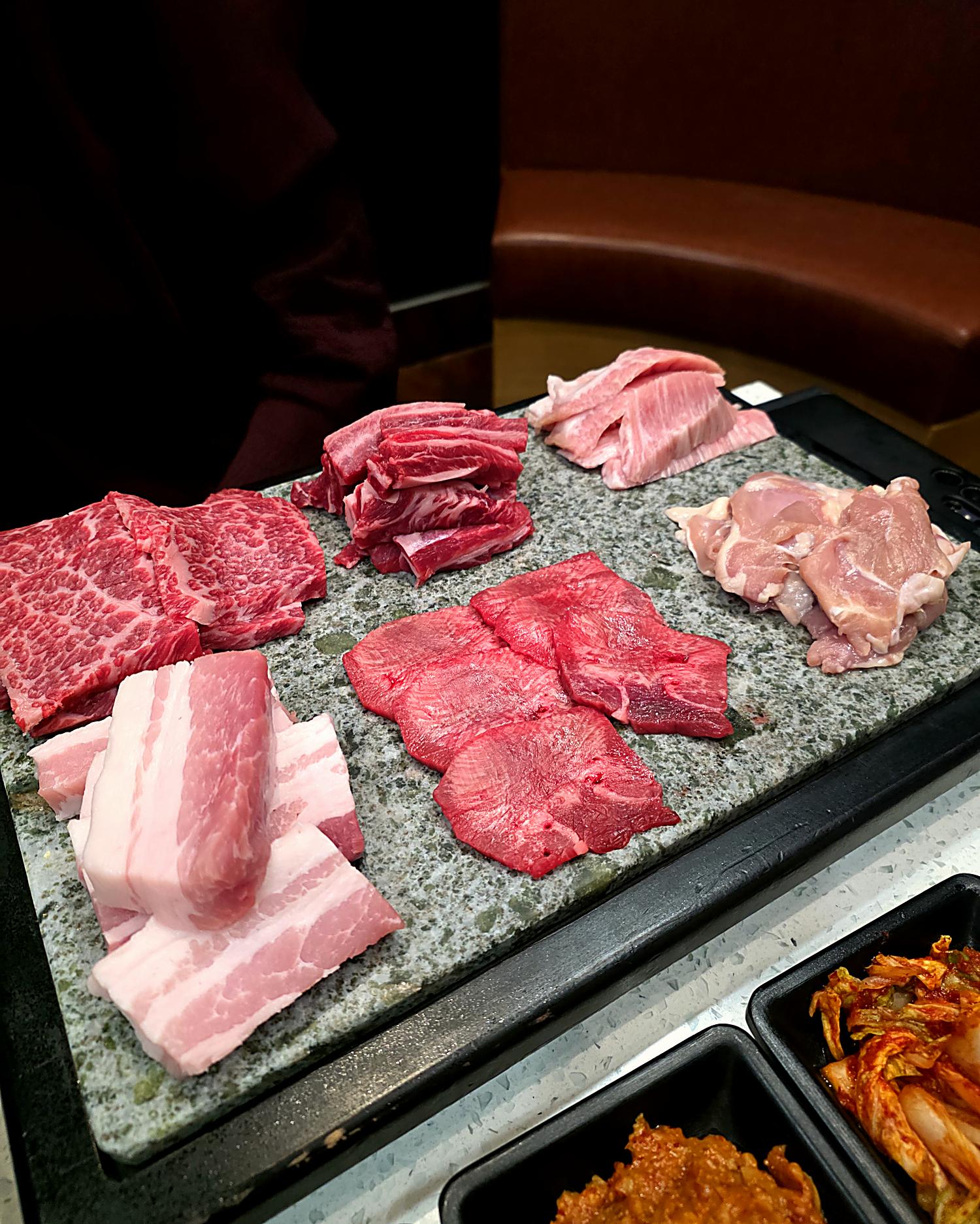 Assorted premium Korean BBQ meats on a stone plate at KOSOO Coquitlam